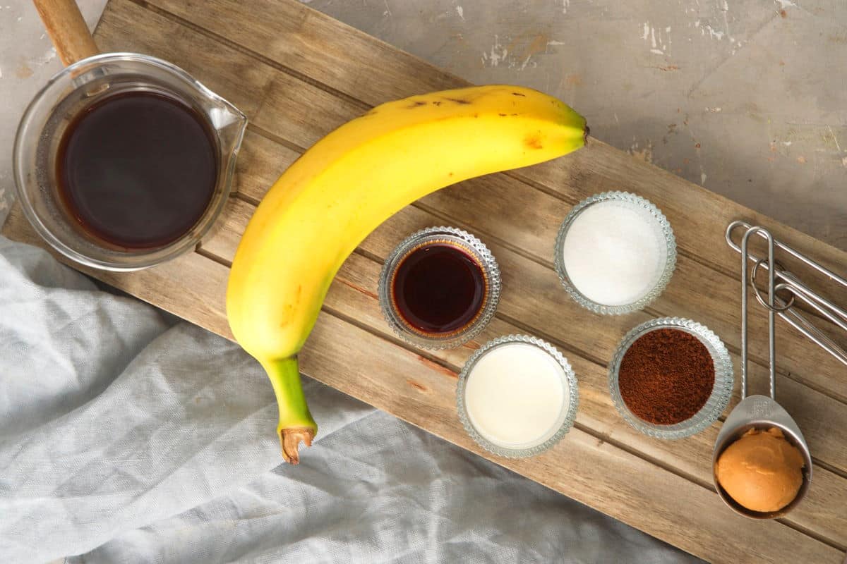Coffee smoothie ingredients prepped on wooden board.