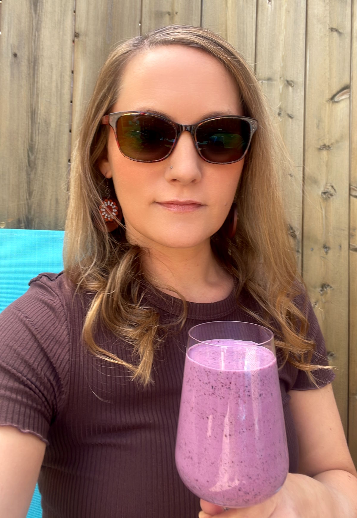 Joss with keto blueberry smoothie on blue chair.