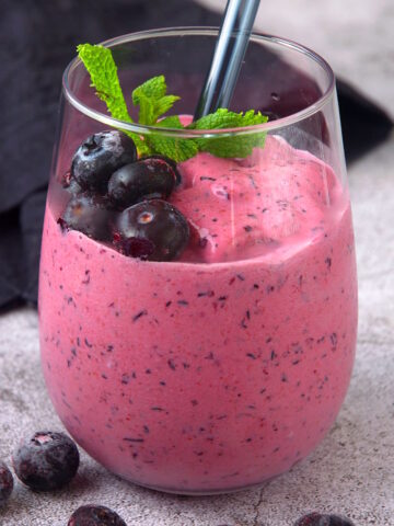 Blueberry keto smoothie in glass with fresh mint.