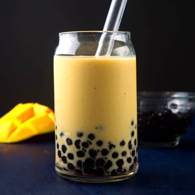 Boba smoothie with mango in glass with straw.
