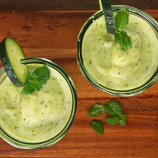 Cucumber smoothie in glasses with cucumber slice garnish.