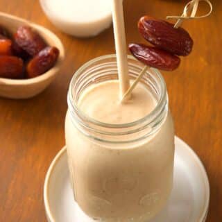 Date smoothie in a glass jar with skewered dates.