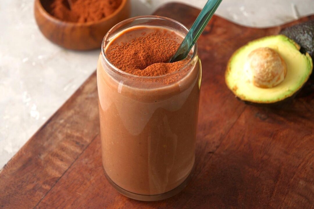 Double chocolate smoothie with straw in glass.