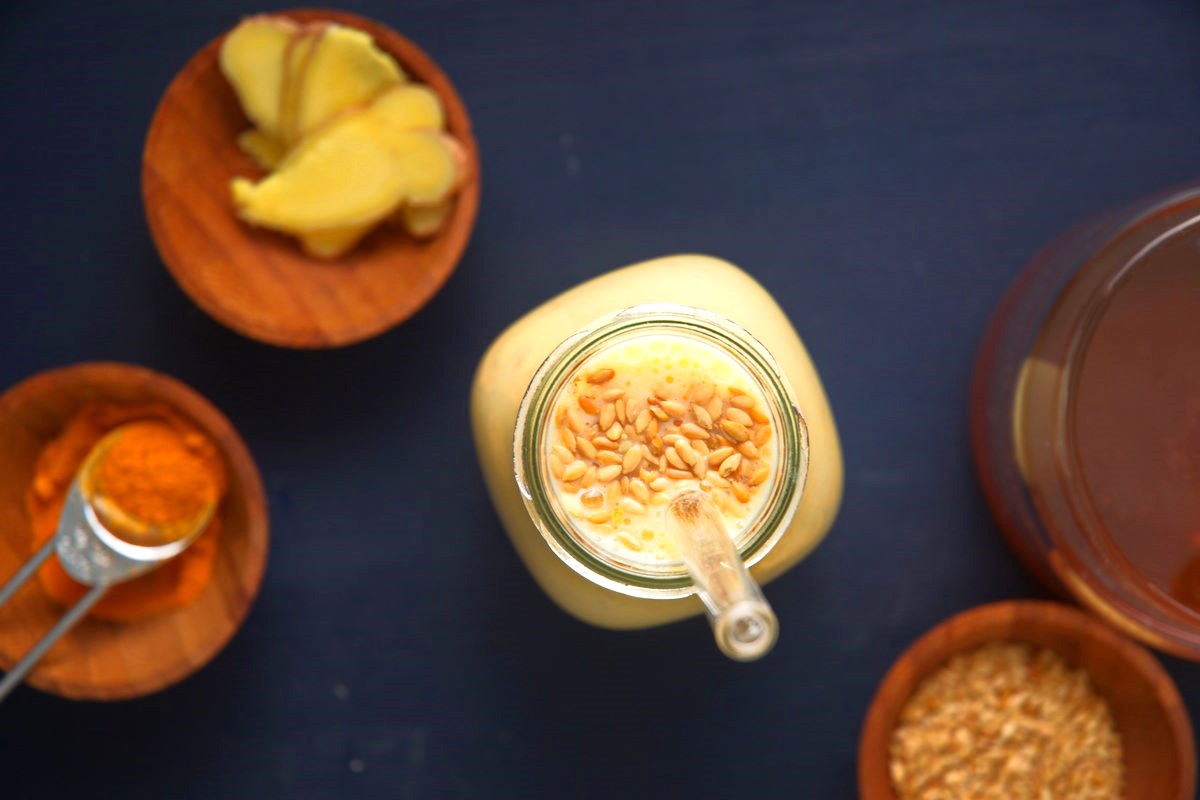 Flax seed smoothie in glass topped with whole flax seeds.