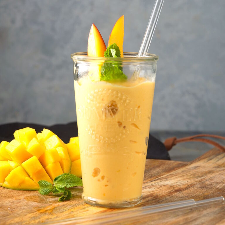 Mango smoothie in tall glass.