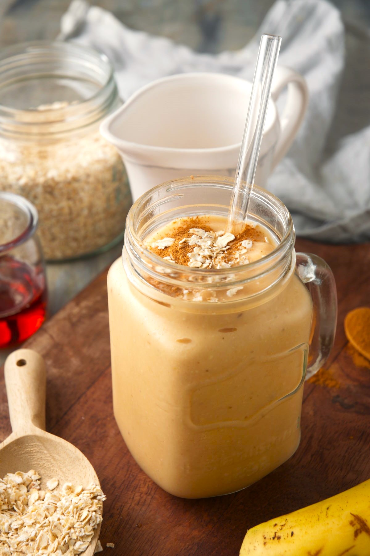 Oatmeal smoothie in glass jar topped with oats and cinnamon powder.