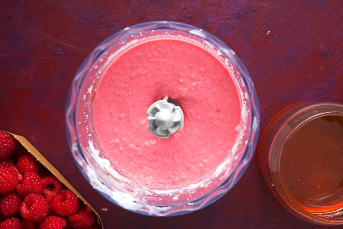 Raspberry smoothie blended in food processor.