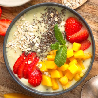 Thick fruit smoothie bowl on wooden background.