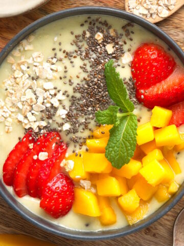 Thick fruit smoothie bowl on wooden background.