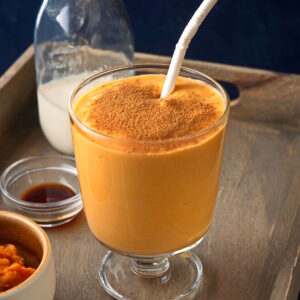 Sweet potato smoothie in glass with cinnamon powder.