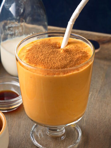Sweet potato smoothie in glass with cinnamon powder.