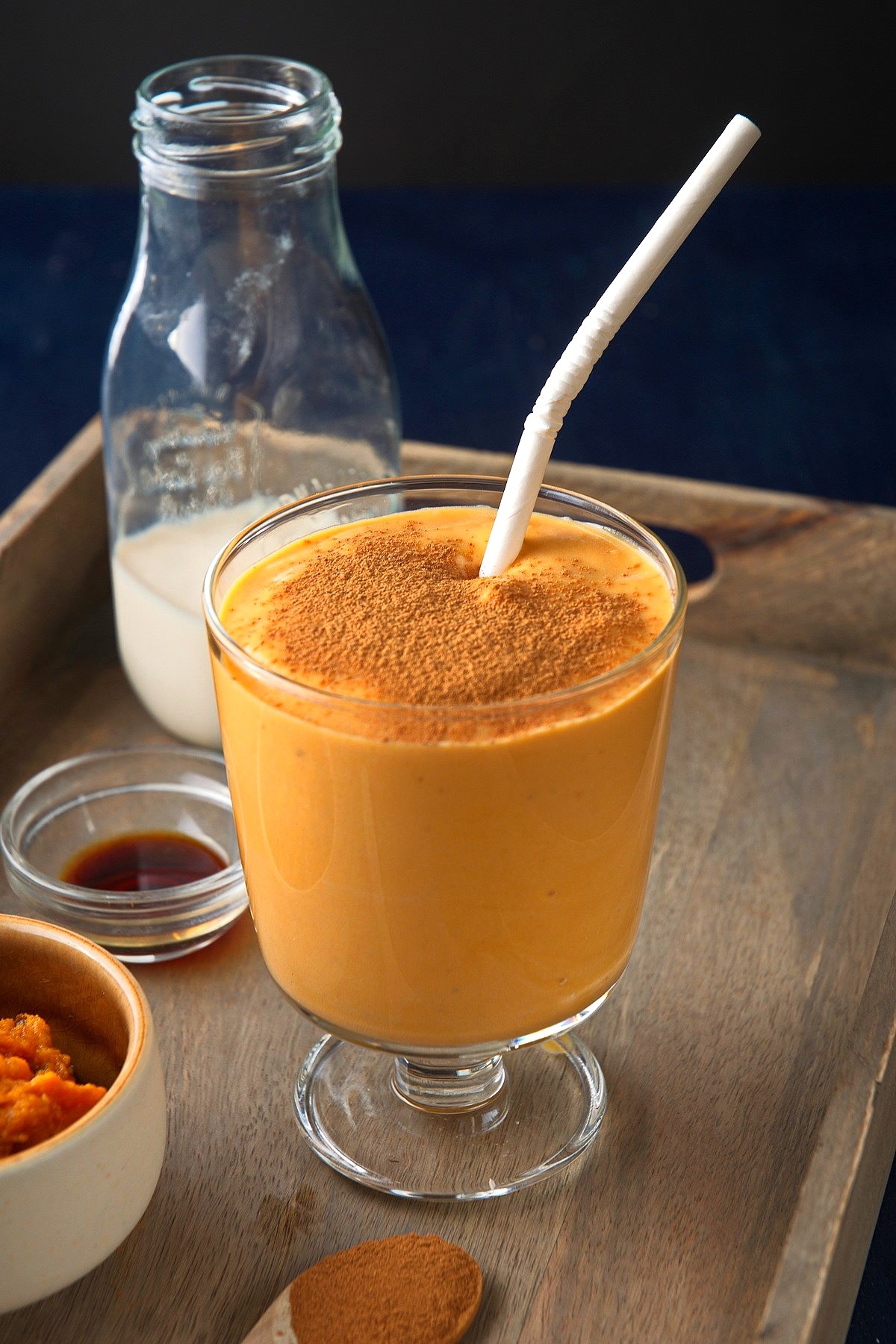 Sweet potato smoothie in glass with almond milk and sweet potato puree on the side.